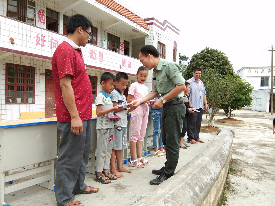 图为第一书记向小学生赠送文具和笔记本.jpg